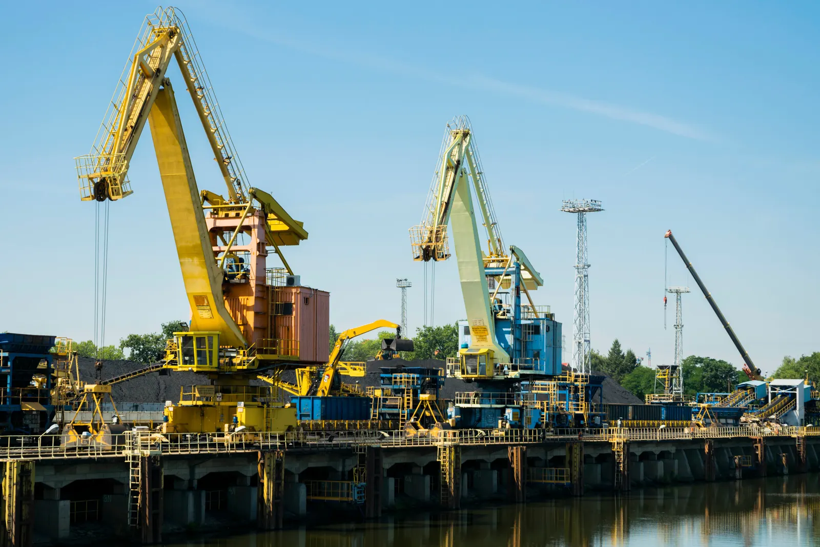 Industrial cranes and heavy equipment at a materials handling yard